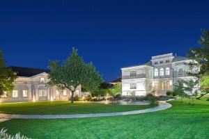 a large white house with a green lawn at night at Apartment mit Gartenblick und Terrasse in Baden