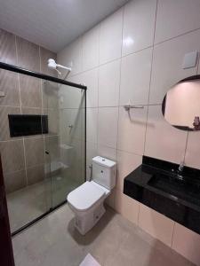 a bathroom with a toilet and a glass shower at Casa para aluguel de temporada in Crato +10 photos