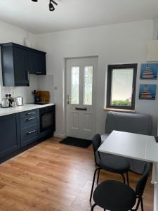 a kitchen with a table and two chairs and a table at Marta Studio Apartment in Ennistymon