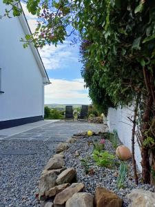 a rock garden in front of a white building at Marta Studio Apartment in Ennistymon