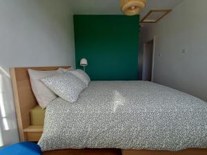 a bedroom with a large bed with a green wall at Marta Studio Apartment in Ennistymon