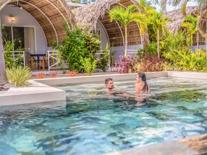 a man and a woman in a swimming pool at Les Voiles Blanches - Luxury Lodge in Tamarindo