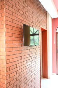 a television on the side of a brick wall at Hotel y Suites Los Encantos in Sayulita