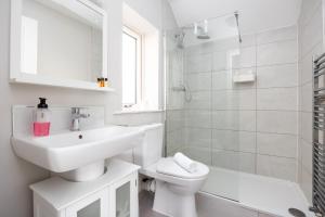 a white bathroom with a sink and a toilet at Modern New Build in Dublin in Dublin +13 photos