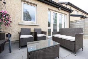 a patio with wicker chairs and a glass table at Modern New Build in Dublin in Dublin