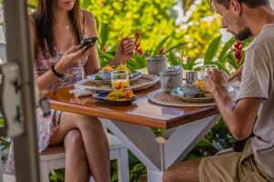 a group of people sitting at a table eating food at Les Voiles Blanches - Luxury Lodge in Tamarindo