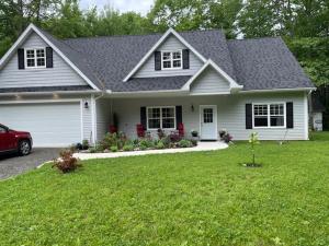 a white house with a car parked in the yard at Harvest Moon Trail Hideaway in Middleton