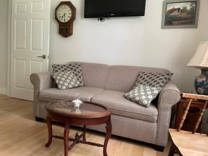 a living room with a couch and a clock on the wall at Harvest Moon Trail Hideaway in Middleton