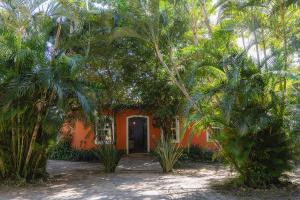 an orange house with palm trees in front of it at Pousada Villa Agrifoglio in Praia do Rosa +85 photos