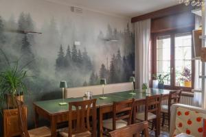 een eetkamer met een tafel en een bosmuurschildering aan de muur bij diana rooms in Lusiana +41 foto's