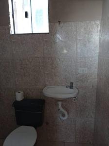 um banheiro com vaso sanitário e pia em Residencial Barbosa - Apto 301 em Macaé