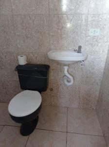 um banheiro com vaso sanitário e pia em Residencial Barbosa - Apto 301 em Macaé