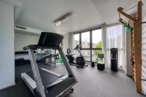 a gym with a treadmill and a tv in a room at Best Western Premier Le Masq H&ocirc;tel in La Rochelle