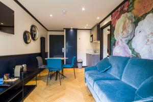 a living room with a blue couch and a table at Best Western Les Bains Hotel et SPA in Perros-Guirec
