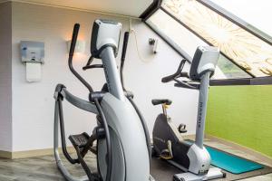a gym with two exercise bikes in front of a window at Best Western Les Bains Hotel et SPA in Perros-Guirec