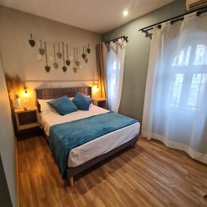 a bedroom with a bed with blue pillows and a window at Hostal Luxury Green Madrid Gran Vía in Madrid