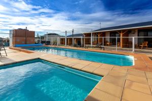 a swimming pool with blue water in front of a building at Beachfront Bicheno in Bicheno