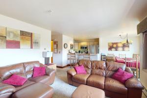 a living room with two brown leather couches and pink pillows at Watch Hill Condos Unit 614 in Silverthorne