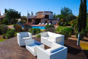 een huis met twee witte stoelen en een zwembad bij 3 bedroom Villa Limni with private pool and gardens, Aphrodite Hills Resort in Kouklia
