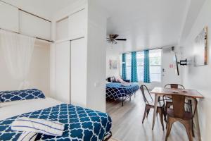 迈阿密海滩Ocean Drive Best Deal, w/2 Queen Beds, Near Beach的一间卧室，里面有一张床、一张桌子和几把椅子。