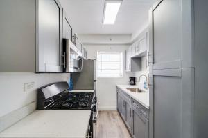 una cucina con mobili bianchi e un forno a piano cottura di Ocean Drive Beach Fun, w/2 Queen Beds South Beach a Miami Beach Altre 33 foto
