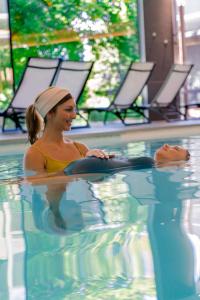 a woman sitting in a swimming pool at Domaine Des Hautes Fagnes in Ovifat +157 photos
