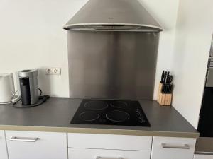 a stove top in a kitchen with a hood at Charmant T3 à la plage in Seignosse