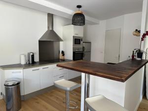 a kitchen with white cabinets and a wooden counter top at Charmant T3 à la plage in Seignosse