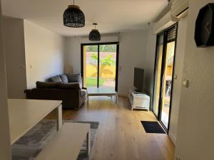 a living room with a couch and a table at Charmant T3 à la plage in Seignosse