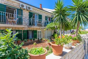 a house with palm trees in front of it at Triple Room Supetar 5658b in Supetar