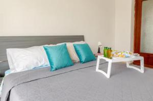 a bed with blue and white pillows and a table at Galileo Train Station Welcome A&A in Santhià