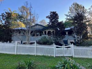 a white picket fence in front of a house at Maringa House in Maleny