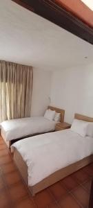 two beds sitting next to each other in a room at Kabila - accès Direct à La Plage in Sania Torres +1 photo
