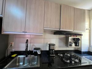 a kitchen with a sink and a stove top oven at Loft Home Vila Bella in Cuiabá