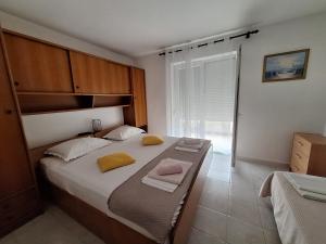 a bedroom with a large bed with two towels on it at Apartments with parking space Supetarska Draga - Donja, Rab - 15999 in Rab