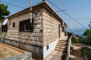 a stone house with stairs leading up to it at Apartments with parking space Splitska, Brac - 2867 in Splitska