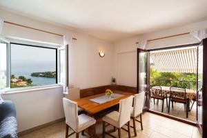 a dining room with a table and chairs and a large window at Apartments with parking space Splitska, Brac - 2867 in Splitska