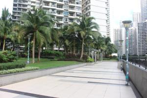 a walkway in a city with palm trees and buildings at Country Garden Danga Bay in Johor Bahru