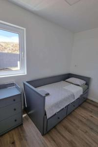 ein Bett in einem weißen Zimmer mit einem Fenster in der Unterkunft Secluded fisherman's cottage Cove Prnjica, Pag - 23456 in Kolan