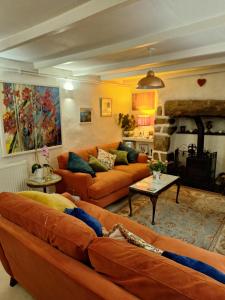 a living room with orange couches and a fireplace at Redmoor in Saint Day