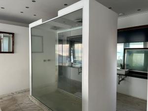 a glass shower in a bathroom with a sink at Villa Romana Búzios in Búzios