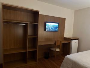 a room with a bed and a tv on a wall at Casa Emma Gramado 3 in Gramado +5 photos