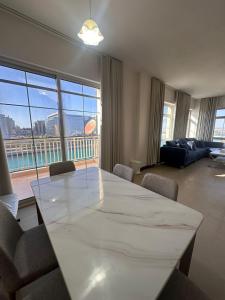 ein Wohnzimmer mit einem großen weißen Tisch und Stühlen in der Unterkunft هبة مارينا مدينة الملك عبدالله الاقتصادية in King Abdullah Economic City