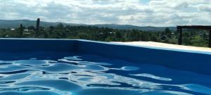 a blue swimming pool with a view of the mountains at Cabaña Maria y Oscar in Villa Giardino