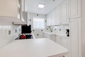 eine Küche mit weißen Schränken und einer weißen Arbeitsplatte in der Unterkunft Sunny Ocean Dr Condo, w/2 Queen Beds, South Beach in Miami Beach + 28 Fotos