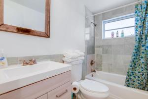 ein Badezimmer mit Waschbecken, Toilette und Spiegel in der Unterkunft Sunny Ocean Dr Condo, w/2 Queen Beds, South Beach in Miami Beach