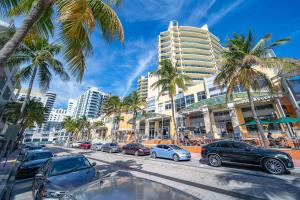 a city street with parked cars and palm trees at Steps 2 Beach, Prime Ocean Dr Condo w/2 Queen Beds in Miami Beach +28 photos