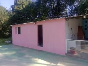 a small pink and white house at Rancho Ohana in Peruíbe