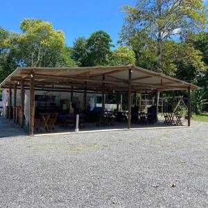 a pavilion with tables and chairs in a park at Rancho Ohana in Peruíbe +92 photos