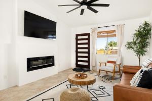 a living room with a fireplace and a tv at Modern Desert Escape - Fire Pit, BBQ and Design! home in Yucca Valley +18 photos